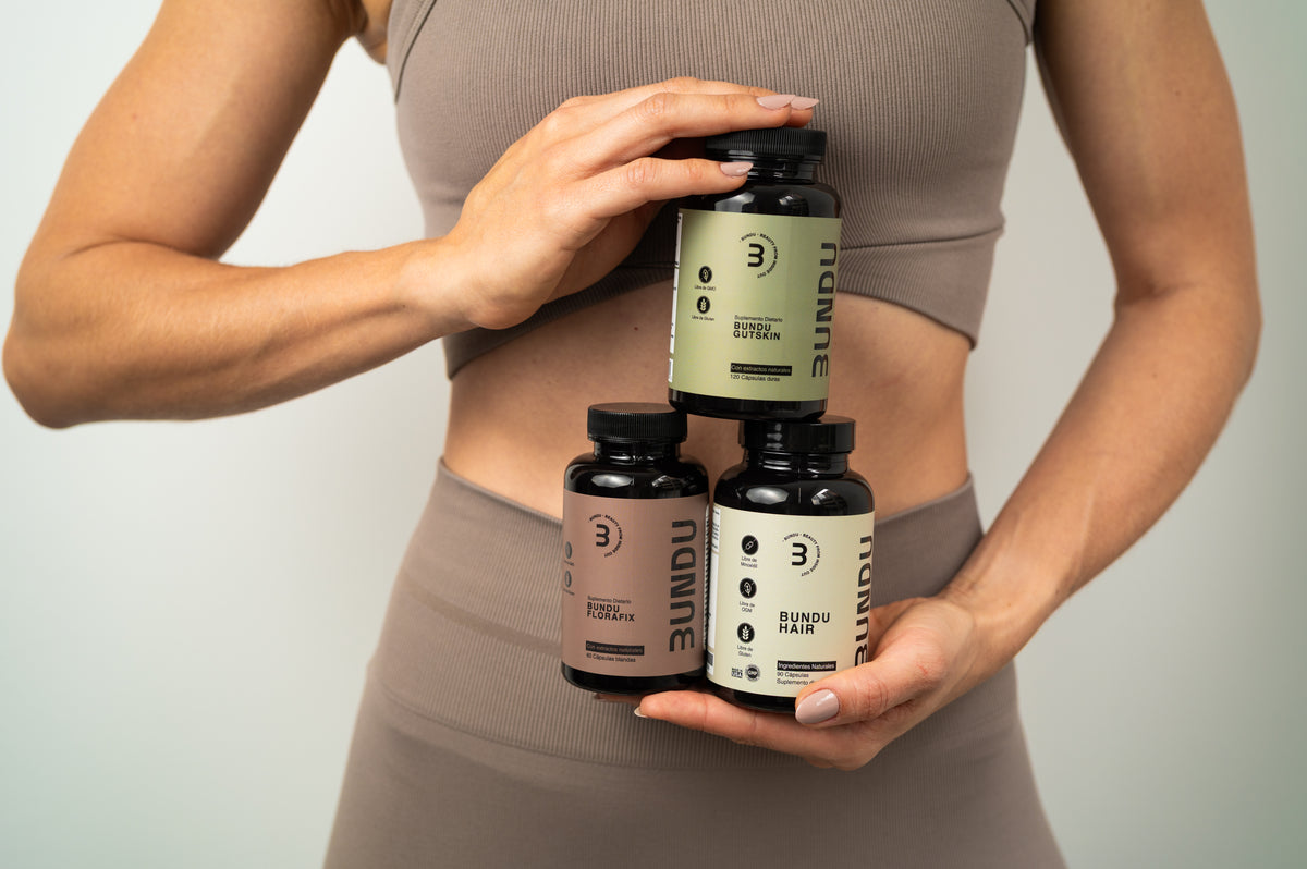 Mujer sosteniendo los frascos de BUNDU Gutskin, Florafix y Hair